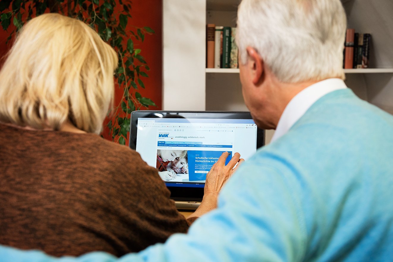 Seniorenpaar am PC Ein älteres Paar am Computer, auf dem Bildschirm sieht man die Facebook-Seite des VdK Deutschland