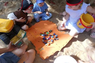 Kinder vor einer Decke auf der verschiedene Sachen liegen