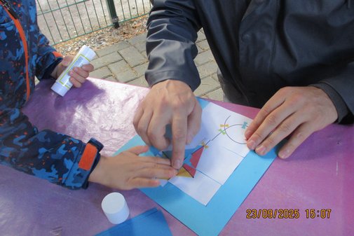 Kinder basteln einen Drachen auf einem Blatt Papier