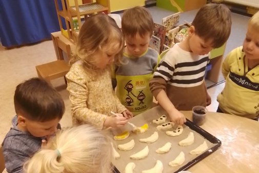 Kinder mit einem Blackblech voller Hörnchen