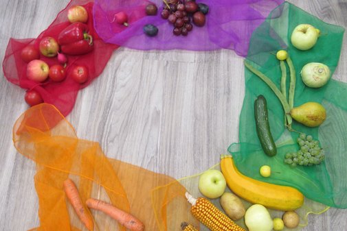 auf bunten Tüchern liegt im Kreis Obst und Gemüse