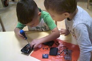 Kinder zerlegen am Tisch einen Fotoapparat