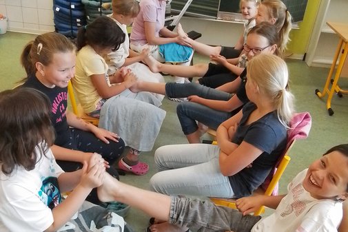 Kinder behandeln sich gegenseitig an den Füßen