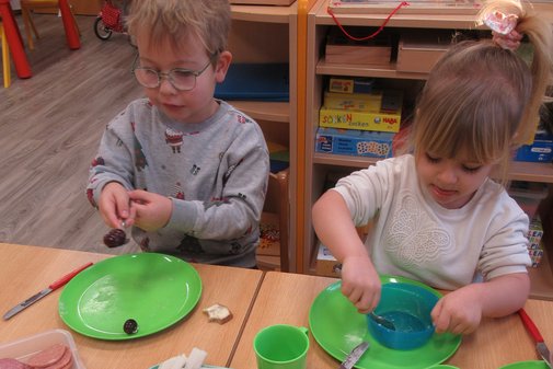 zwei Kinder bereiten sich Fr&uuml;hst&uuml;ck vor