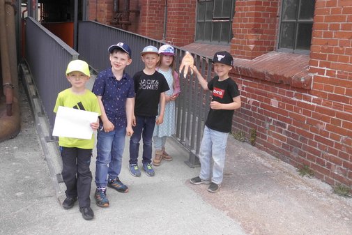 eine Kindergruppe steht vor einem gro&szlig;en Geb&auml;ude