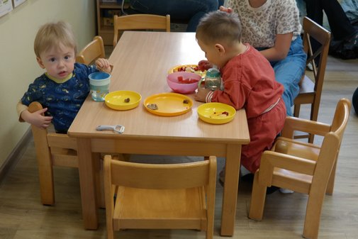 zwei kleine Kinder essen an einem Tisch