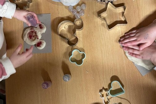 Kinderh&auml;nde stechen Pl&auml;tzchenteig mit Formen aus