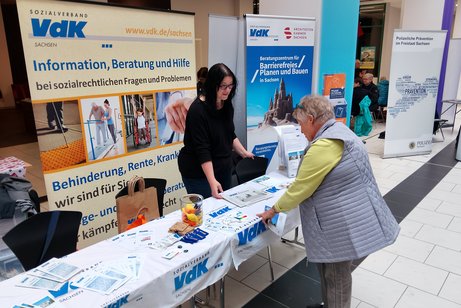 zwei Frauen an einem Infostand mit Material
