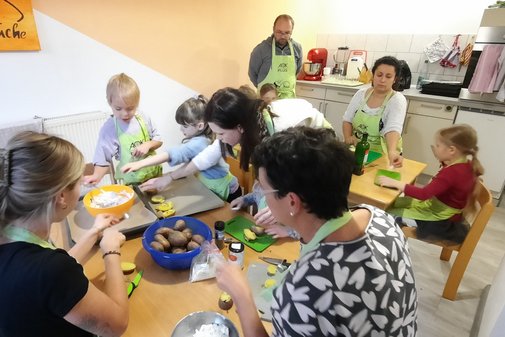 Erwachsene und Kinder schneiden Essen