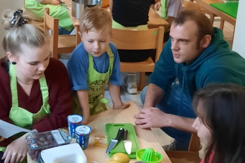 Kinder und Erwachsene bereiten Essen zu