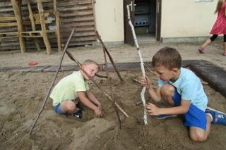 Kinder spielen mit Naturmaterialien im Sandkasten