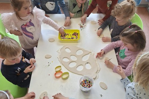 Kinder sitzen um einen Tisch und basteln zum Thema Ostern.