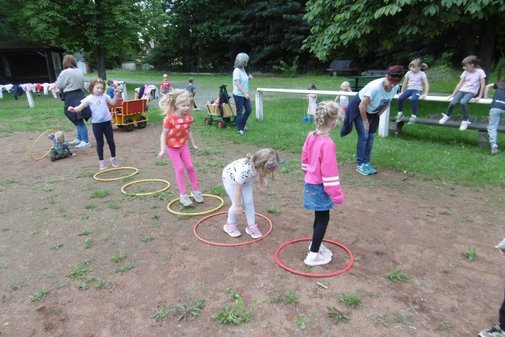 Kinder hüpfen in Ringe, die am Boden liegen