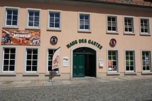 Rosa Haus mit Aufschrift Haus des Gastes