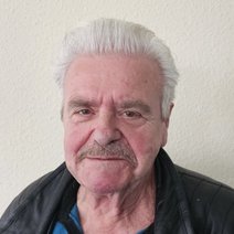 älterer Herr mit grauen Haar, freundlich lächelnd
