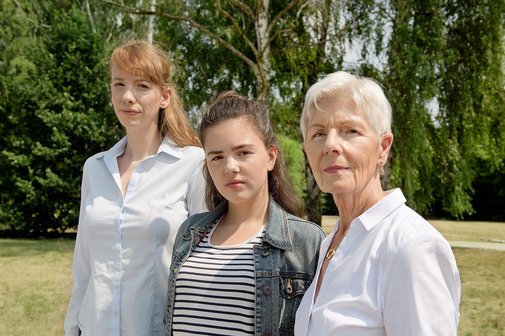 Drei Frauen blicken gemeinsam ernst in die Kamera: Eine j&uuml;ngere, eine Teenagerin und eine &auml;ltere Frau.