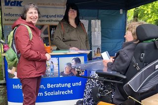 ein Infostand mit mehreren Frauen, eine davon im Rollstuhl