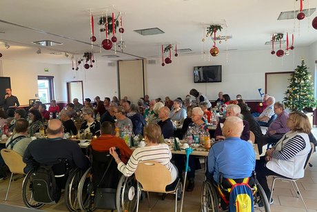 Mitglieder sitzen an langen Tischen