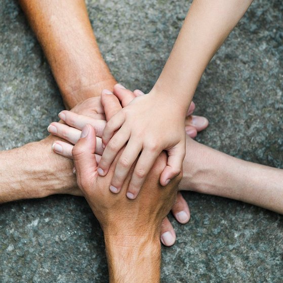 F&uuml;nf Personen legen jeweils eine Hand aufeinander, so dass ein Kreis bzw. ein Stern entsteht