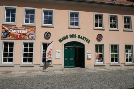 Rosa Haus mit Aufschrift Haus des Gastes